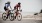 Two people biking on the street near our townhomes in San Pedro, CA, featuring a view of the beach and ocean.